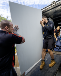 Removalists carrying an office desk during a Frankston office move