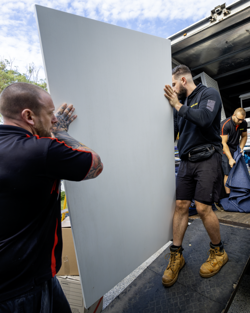 Removalists carrying an office desk during a Frankston office move